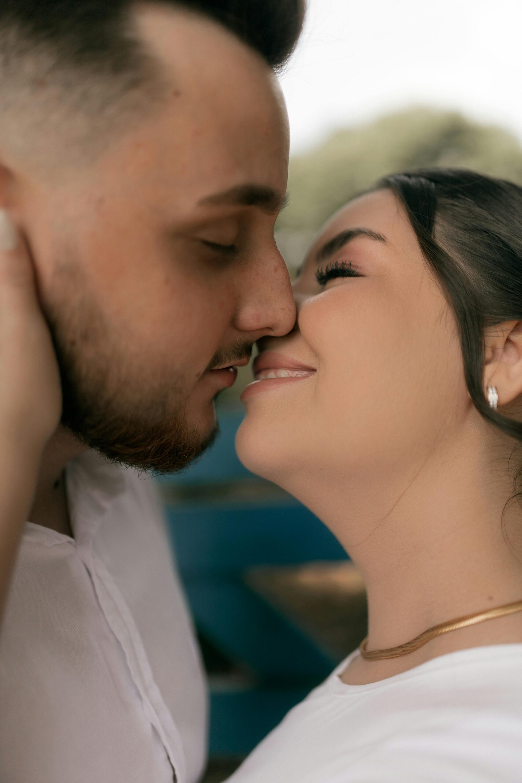 Romantic moment of a couple embracing closely, sharing affection outdoors.